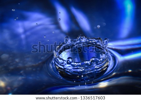 Close up of a blue water drop, macro photography. Falling water drop into water making crown.