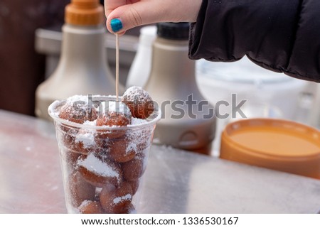 donuts with icing sugar in a cup