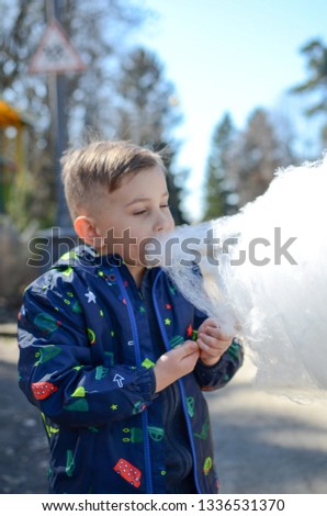 Little boy is enjoying cotton candy.