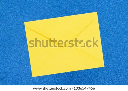 Blank yellow envelope on blue sparkle paper that you can use as a mock up for your message