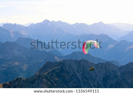 A paraglider sails with a stunning panoramic views over the alps Royalty-Free Stock Photo #1336549115