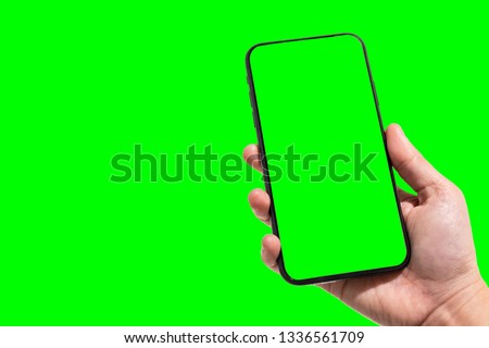 Close-up of female use Hand holding smartphone blurred images touch of green screen background.