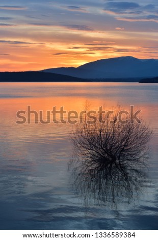 Incredibly Beautiful Sunset or Sunrise landscape.Sky with amazing colorful clouds.Natural Water Reflections.Magic Artistic Wallpaper.Creative Nature Background.Art Photography.Orange and Blue Colors.