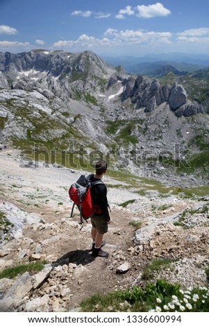 Hiker in a alpine muntain lanscape  Royalty-Free Stock Photo #1336600994