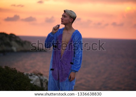 Young guy at sunset in a toy suit