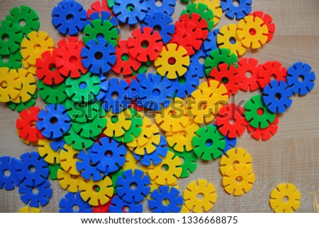 Color children's round meccano on a light wooden background. perfect background for inscriptions, designs and banners