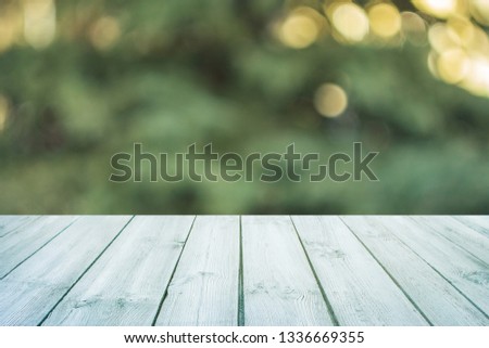 Empty blue wooden table with blurred city park on background. concept party, products, spring background