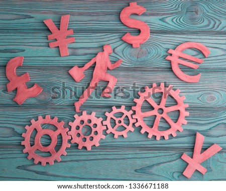 Running man, gears, currency signs on a wooden background. business, Finance. money.