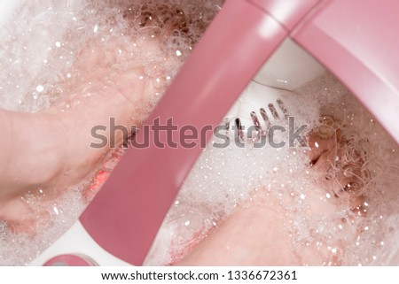 women's feet in an electric foot spa