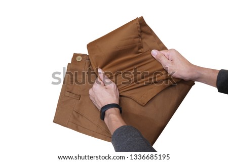 Chino pants spandex brown color stretch by men hand. Royalty-Free Stock Photo #1336685195