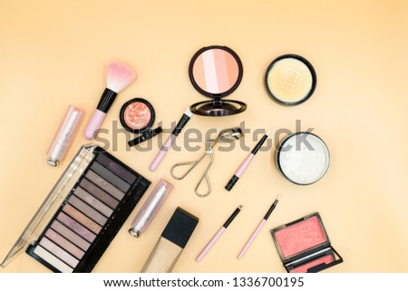 Flat lay composition with skin foundation, powder and beauty accessories.Cosmetic beauty products arranged on a pastel background.