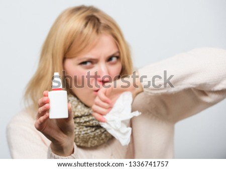 Pharmacist recommended. Sick woman spraying medication into nose. Cute woman nursing nasal cold or allergy. Unhealthy girl with runny nose using nasal spray. Treating common cold or allergic rhinitis.