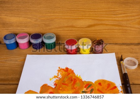 Colored gouache cans on wooden background, Paint for drawing. Kindergarten and school. Multi-colored paint. Children's creativity. Palette with oil paints and gouache. Workplace of the artist.
