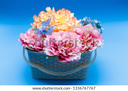 Spring flowers in basket on blue background