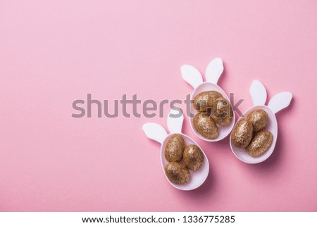 Gold glitter eggs in a white easter bunny egg shape with ears