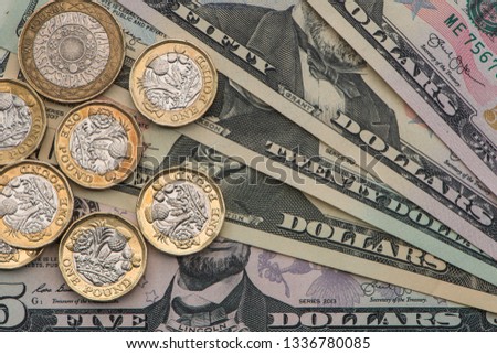 British Pound coins and US Dollars. Close up view from above Royalty-Free Stock Photo #1336780085