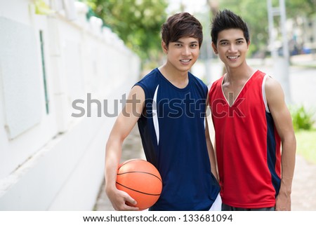 Portrait of two young boys with a ball looking at camera