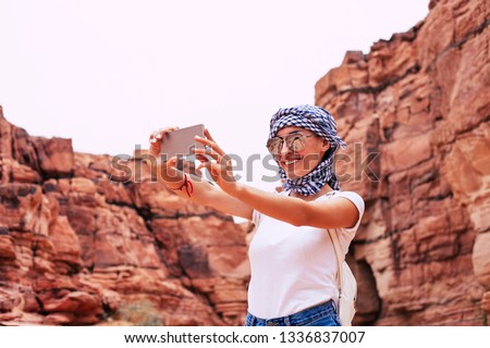 Fairy selfie. Woman with a splendid smile with a smartphone in her hands wearing an outfit for a hot summer weather and making a selfie for her profile on a social media.