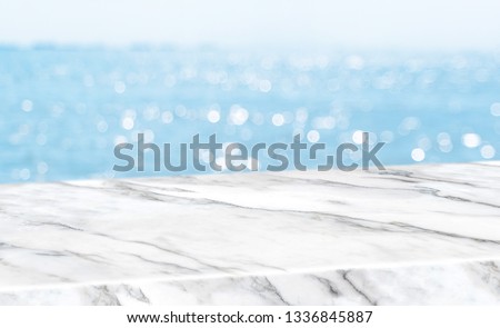 Empty glossy white marble table top with blur sky and sea boekh background,banner mock up template for display of product Royalty-Free Stock Photo #1336845887
