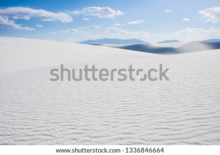 Sunny day and beautiful view with white sand dunes and blue cloudy sky in New Mexico desert.