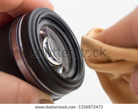 mirrorless system camera lens cleaning. person is cleaning the lens with a cloth