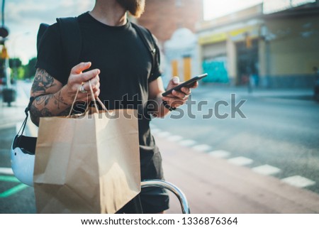 Courier bicycle delivery food service at home.Bearded Man courier using a map app on mobile phone to find the delivery address in the city.