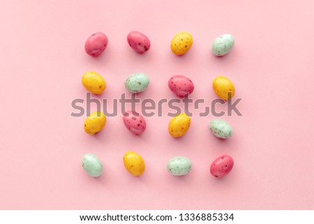 Easter chocolate eggs candy on a pastel pink background, creative flat lay easter concept, top view