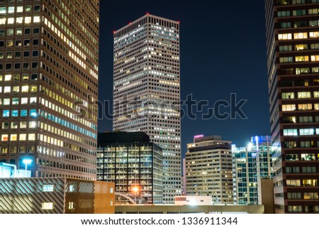 City lights glowing in blues and whites night time downtown urban view in Denver Colorado skyline cityscape Nightscape of skyscrapers illuminated