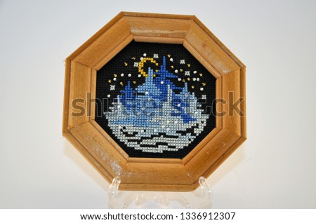 Cross stitched paintings in wooden frame
