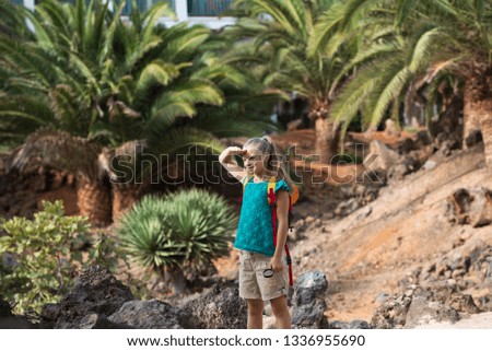 Smiling girl with magnifying glass in the tropical forest