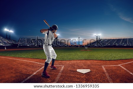 Baseball player at professional baseball stadium in evening during a game.