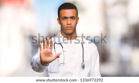 Young afro american man doctor making stop gesture denying a situation that thinks wrong at outdoors