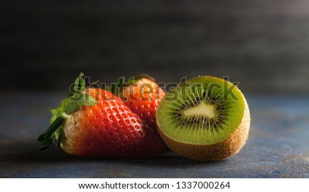 RED STRAWBERRIES AND GREEN KIWI ON DARK BACKGROUND Royalty-Free Stock Photo #1337000264