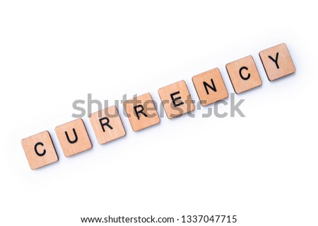 The word CURRENCY, spelt with wooden letter tiles over a white background. 