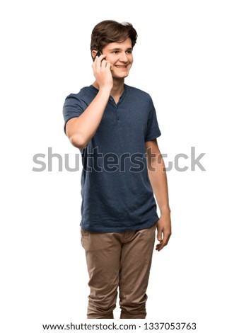 Teenager man keeping a conversation with the mobile phone over isolated white background