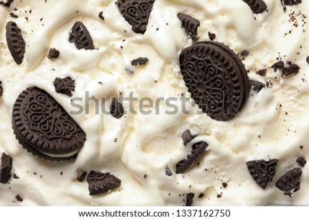Tasty ice cream with chocolate sandwich cookies as background, top view