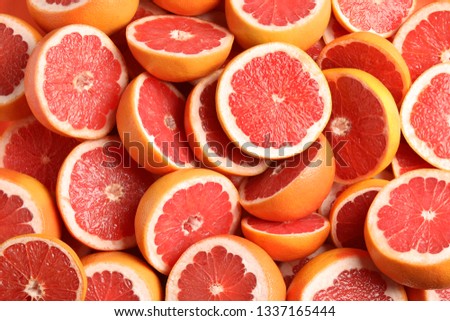 Many sliced fresh grapefruits as background, top view Royalty-Free Stock Photo #1337165444