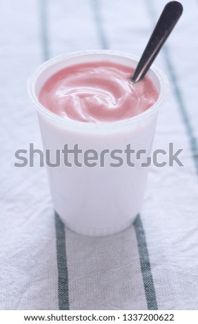strawberry yogurt with spoon in white cup (cylinder cup shape)