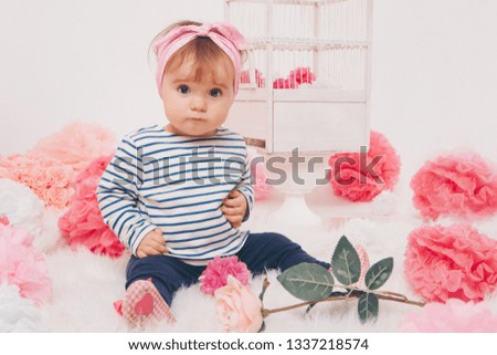 top view: the girl child mother sitting on the floor among the numbers 1, artificial flowers and a bird cage