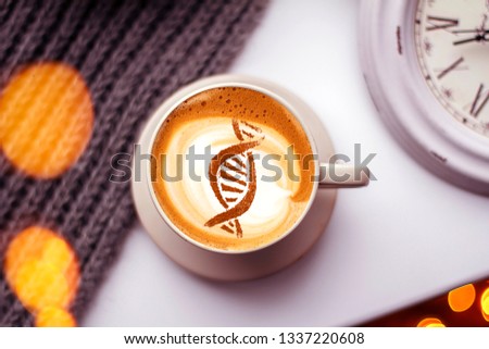 a cup of cappuccino coffee with a picture of a chain of dna