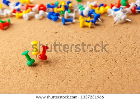 Group of colorful push pins on cork bulletin board