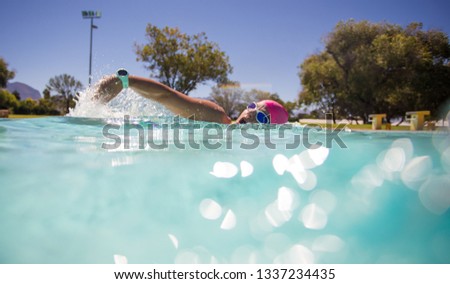 Close up wide angle photo of a female swimmer underwater in a swimming pool