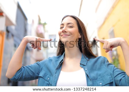 Front view portrait of a proud woman pointing herself in the street Royalty-Free Stock Photo #1337248214