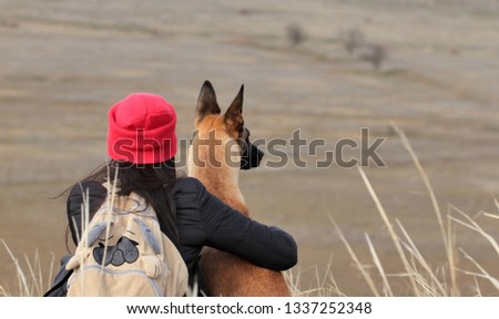 Girl and dog on the spring nature, the breed of the Belgian Shepherd Malinois