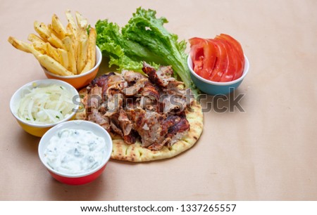 Gyro pita ingredients. Shawarma, gyros, pita bread, vegetables and tzatziki sauce, copy space. Traditional turkish, greek meat food.