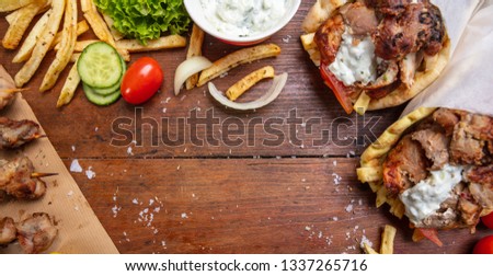 Gyro pita, shawarma, souvlaki. Traditional turkish, greek meat food. Two pita bread wraps and meat skewers on wooden table, banner, top view