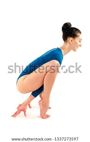 Beautiful slim girl in a blue bodysuit yoga trainer does assans. Isolated on white background
