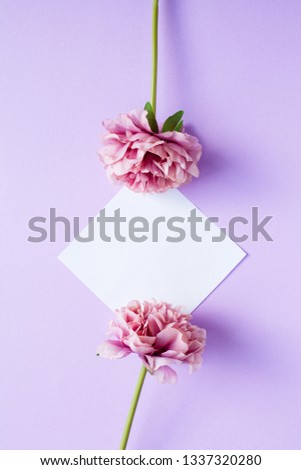Mockup on violet background with white paper sheet and peony flowers, top view. Flat lay style
