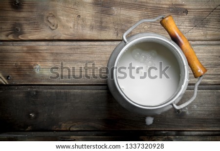 Fresh milk in a can. On a wooden background. Royalty-Free Stock Photo #1337320928