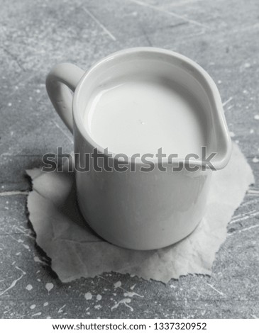 Milk in a cup on paper. On a rustic background .